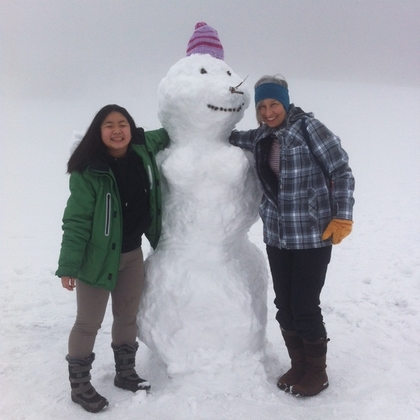 Die glückliche Mama mit Um aus Thailand mit einer riesigen Schneefrau